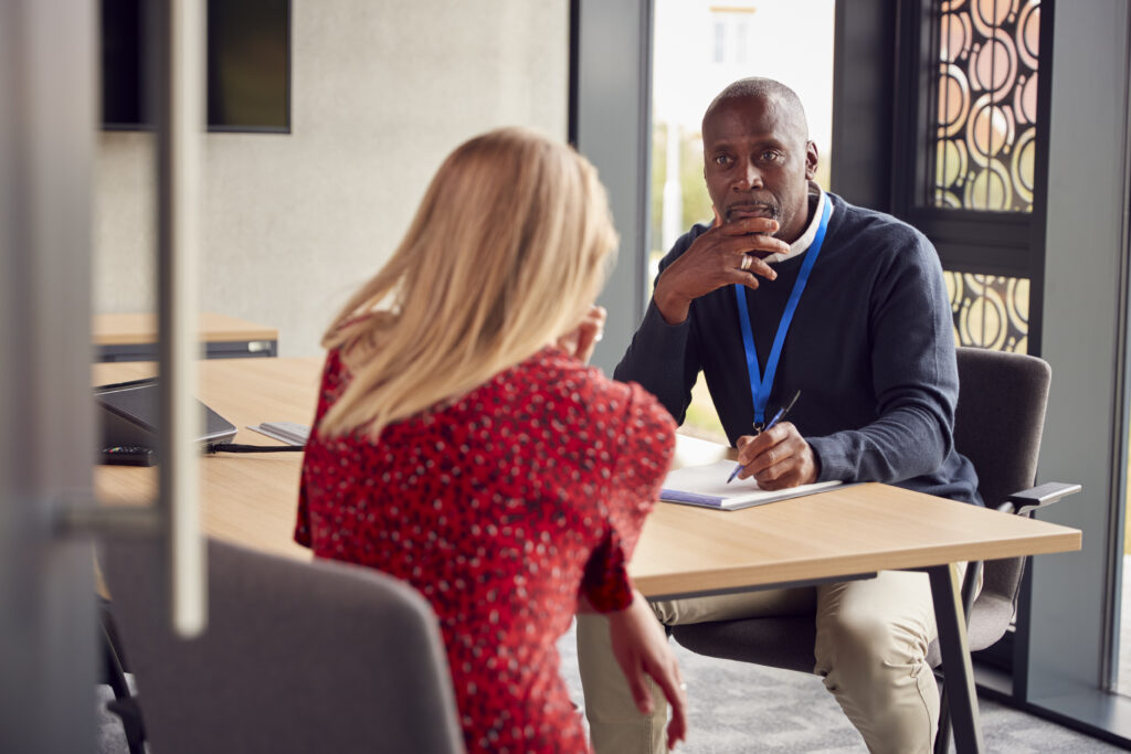 Photo of a Witness Service supporter talking to a witness with long blonde hair.